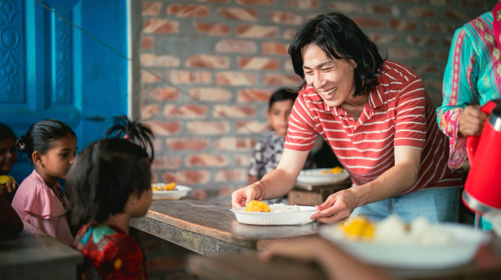 施設の子どもたちの食卓に、ご飯を配る古川十豊